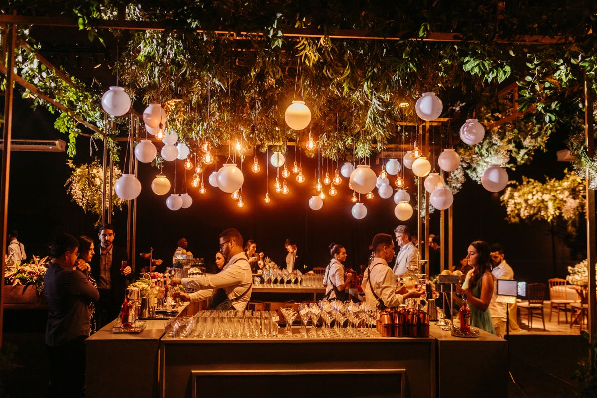 Bartenders serving guests at an outdoor wedding reception bar